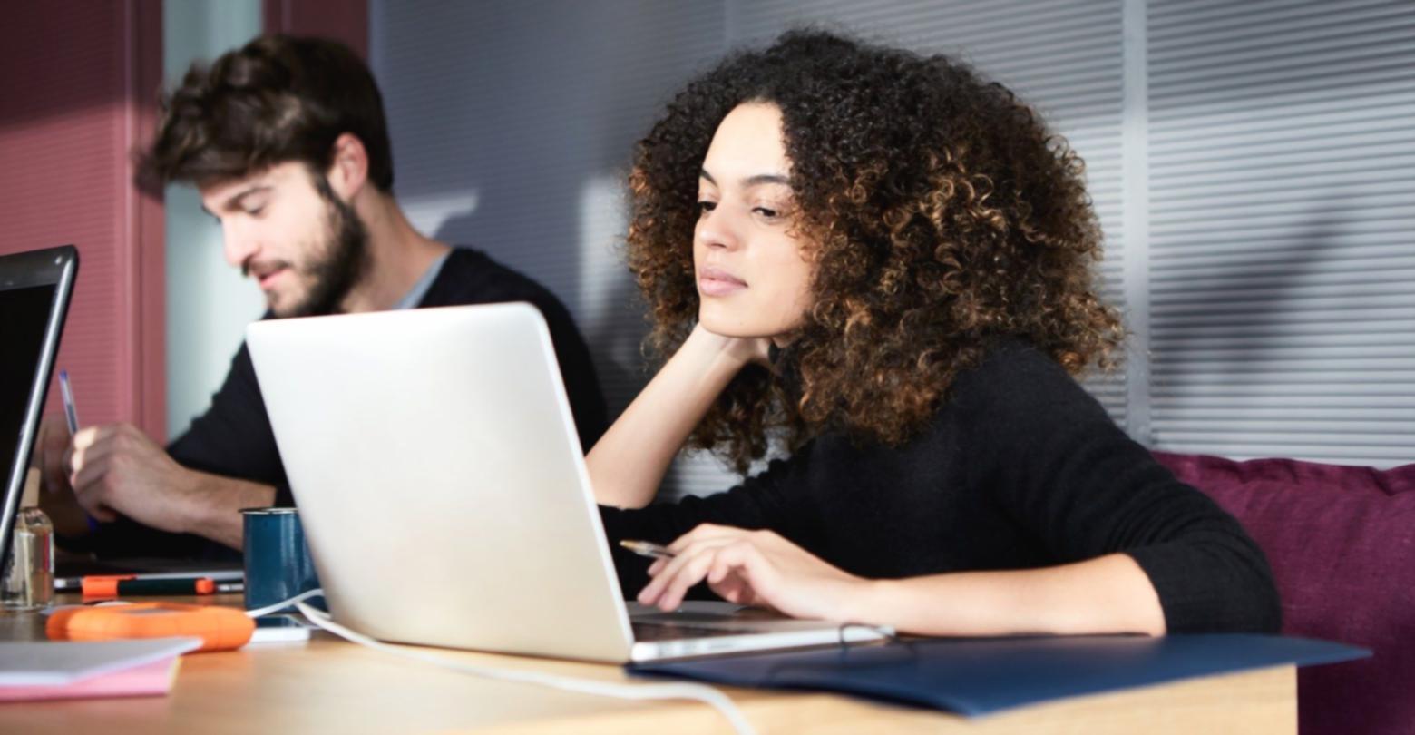 Arbeitsplatz mit Laptop und journalistischen Materialien